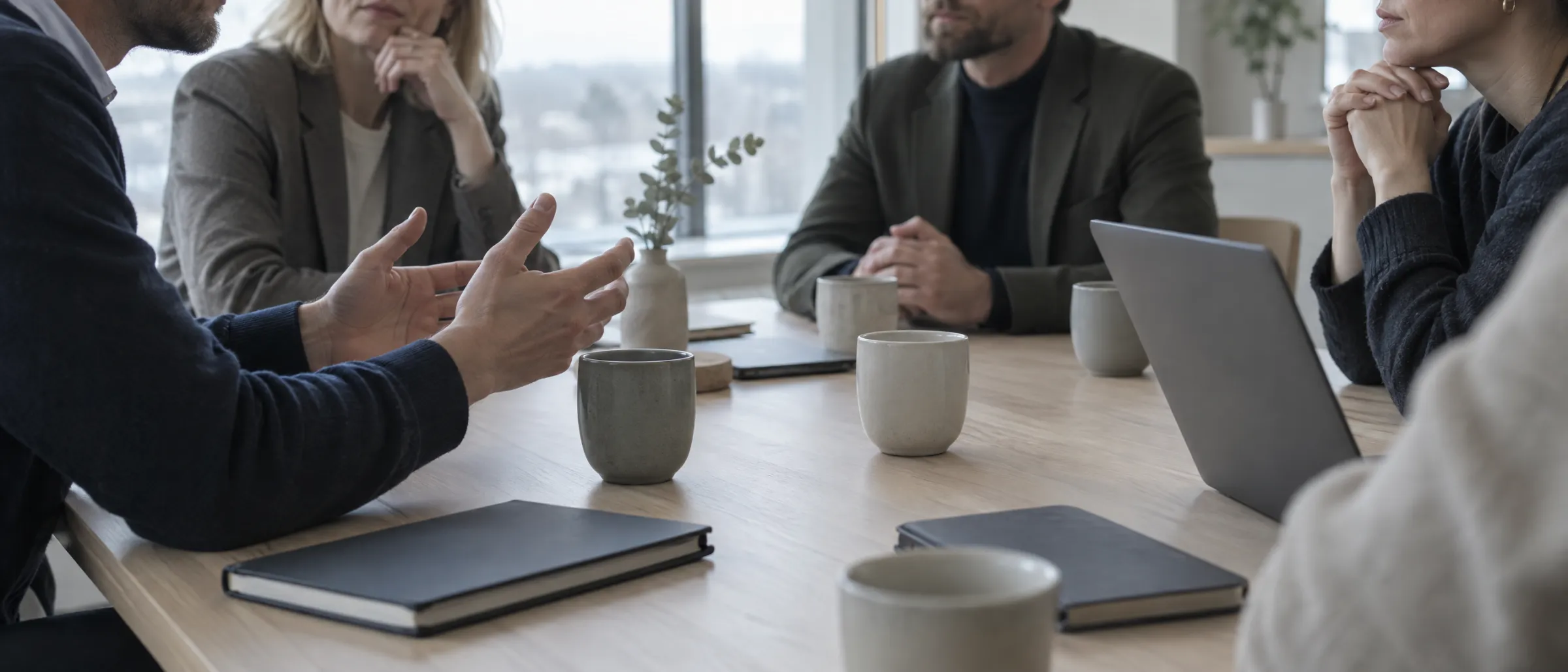 A board meeting mid-conversation, with notebooks closed and nobody taking notes