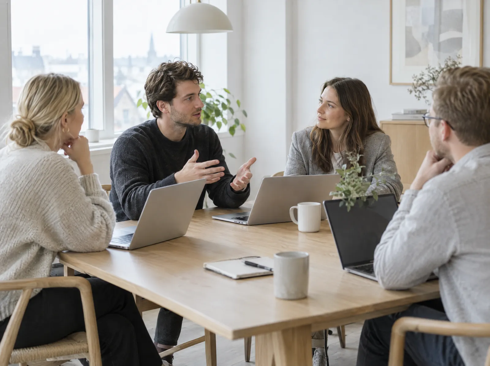 Four colleagues around a table, one explaining while the others listen